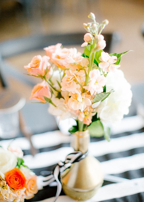 gold bottle and floral centerpiece @weddingchicks