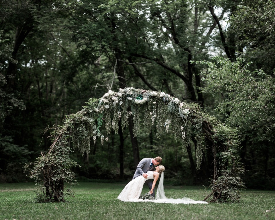 Kiss underneath a floral arch