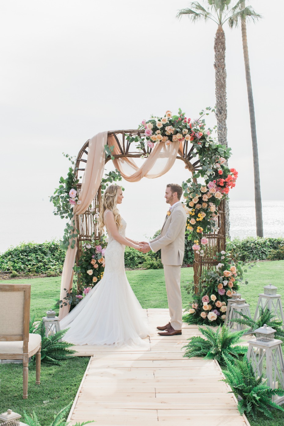 Colorful oceanfront wedding with rose arbor