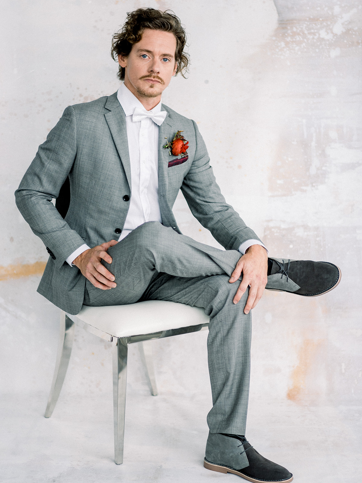 groom in grey suite and white bow tie