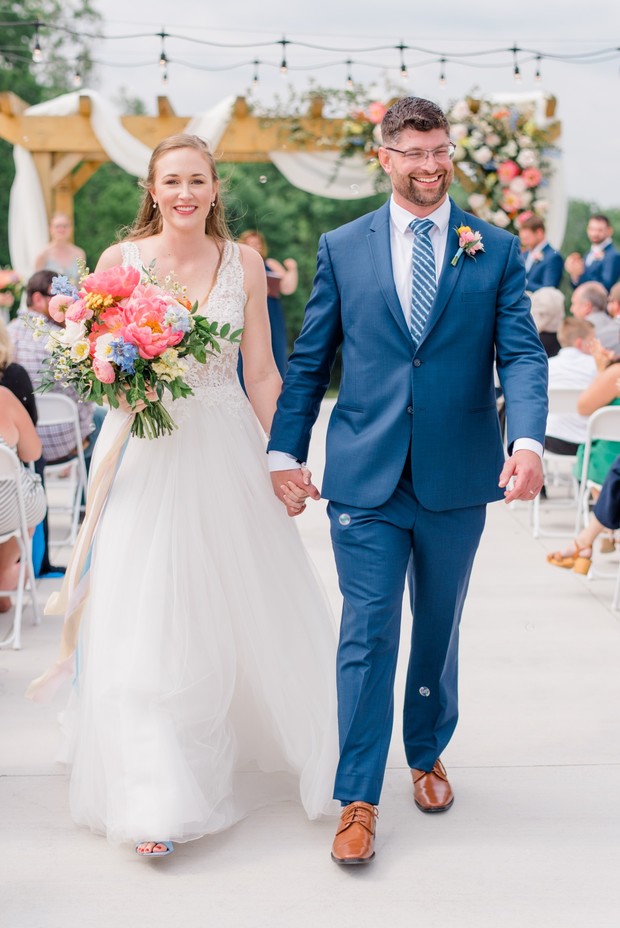 guests blow bubbles as the couple exits the wedding ceremony