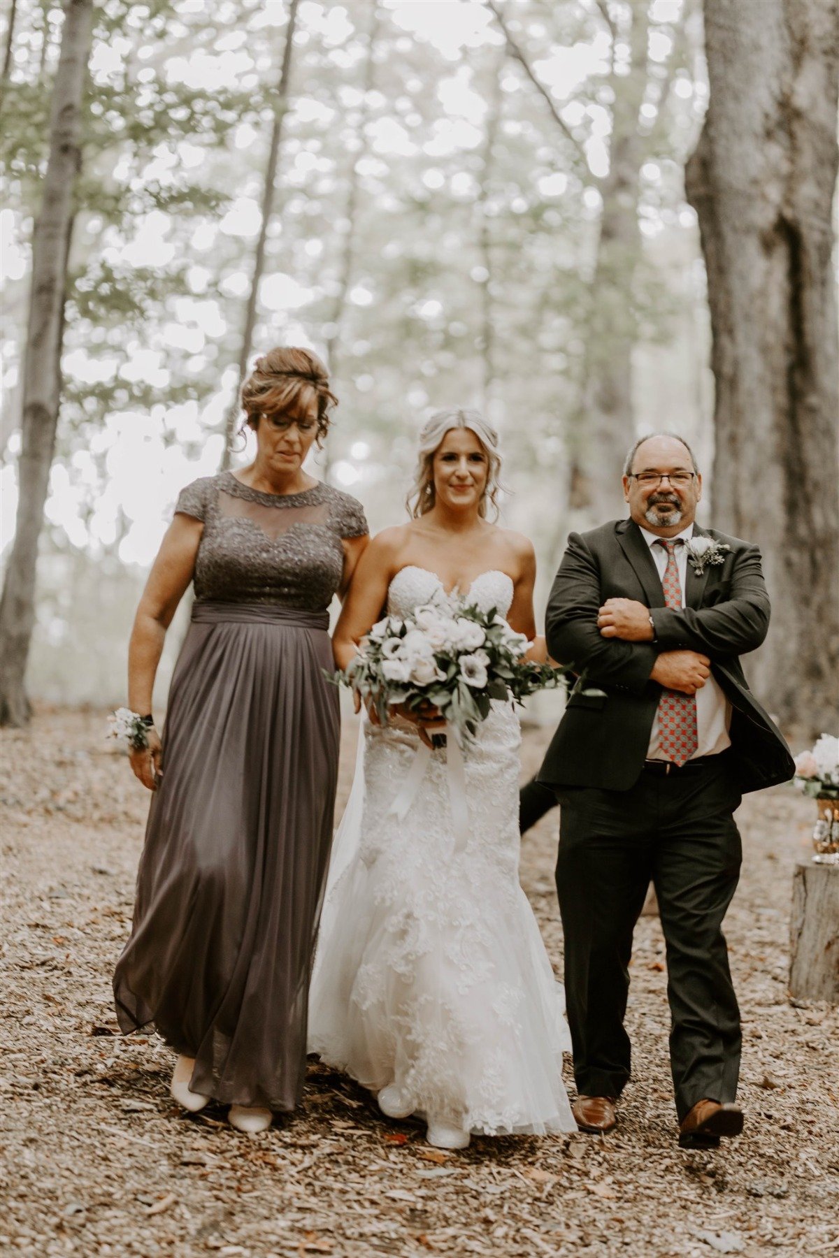 bride being walked down the aisle by Mom and Dad