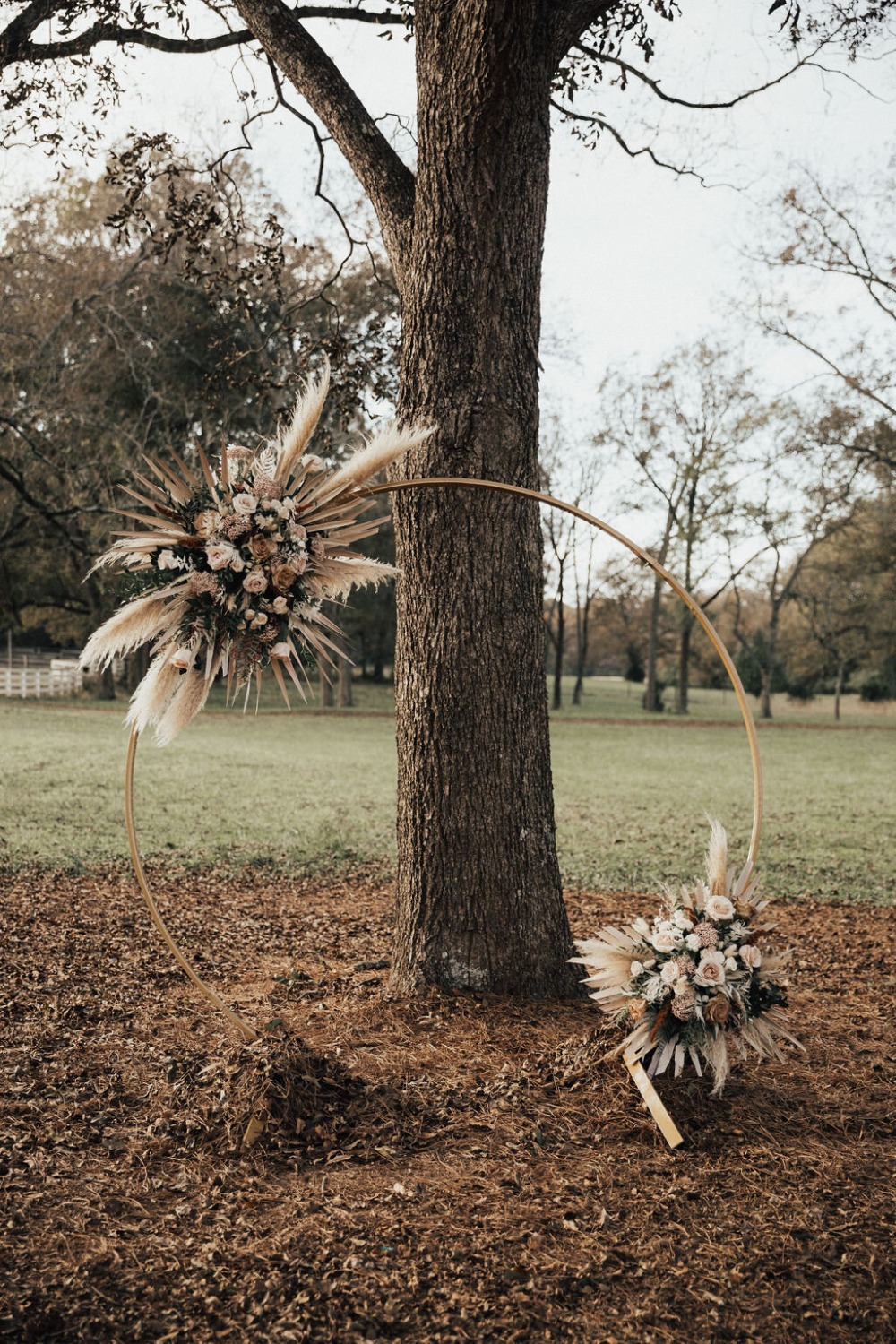 gold hoop circle backdrop with pampas grass arrangement