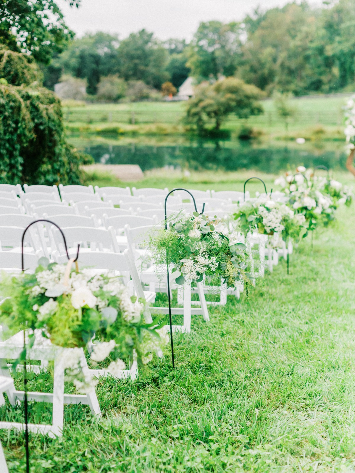 Floral arrangements down aisle of ceremony