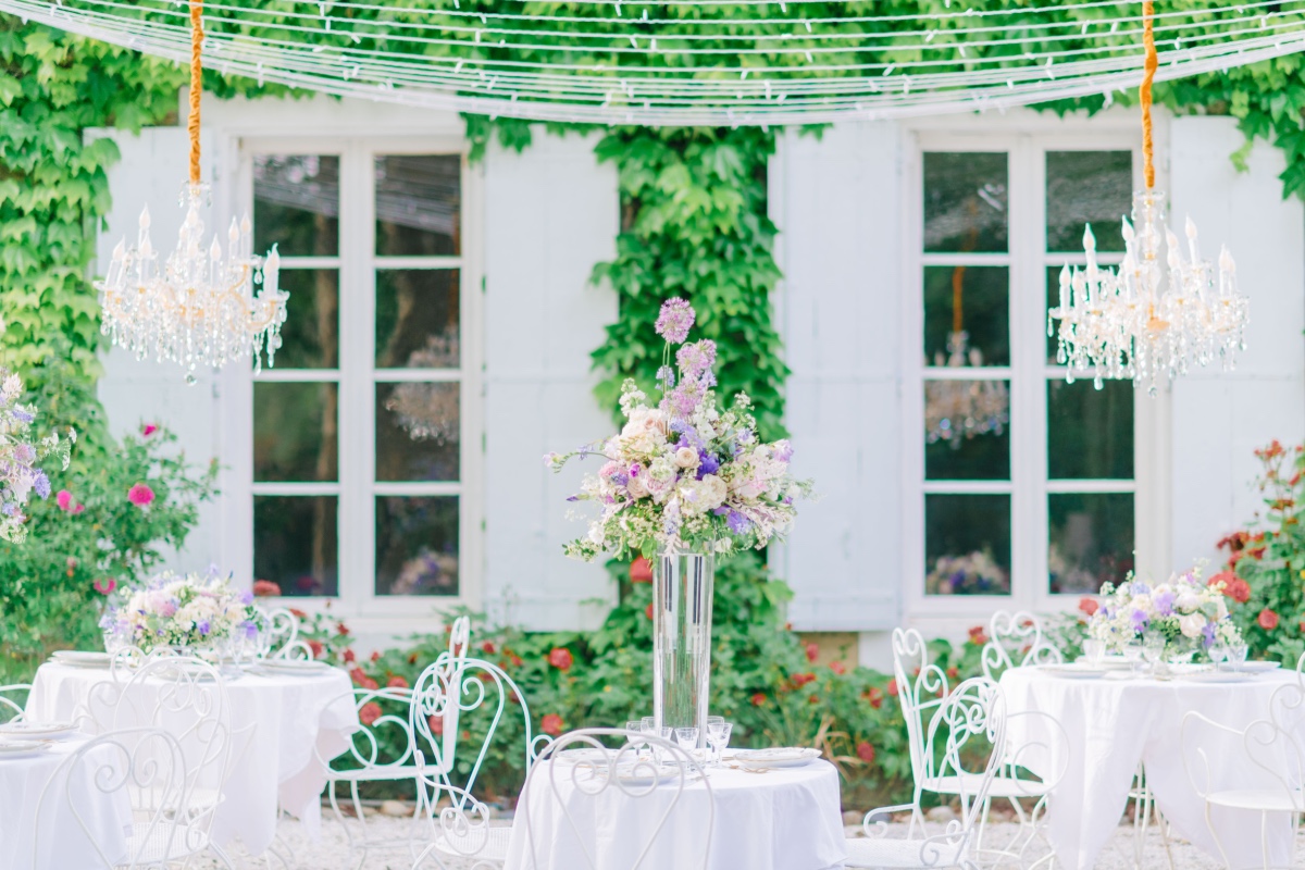 Reception tables with string lights and crystal chandeliers