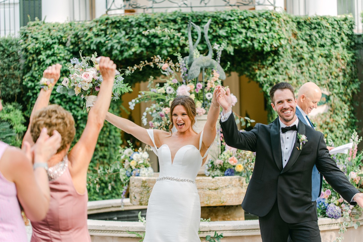 Bride and groom celebrating with hands in the air