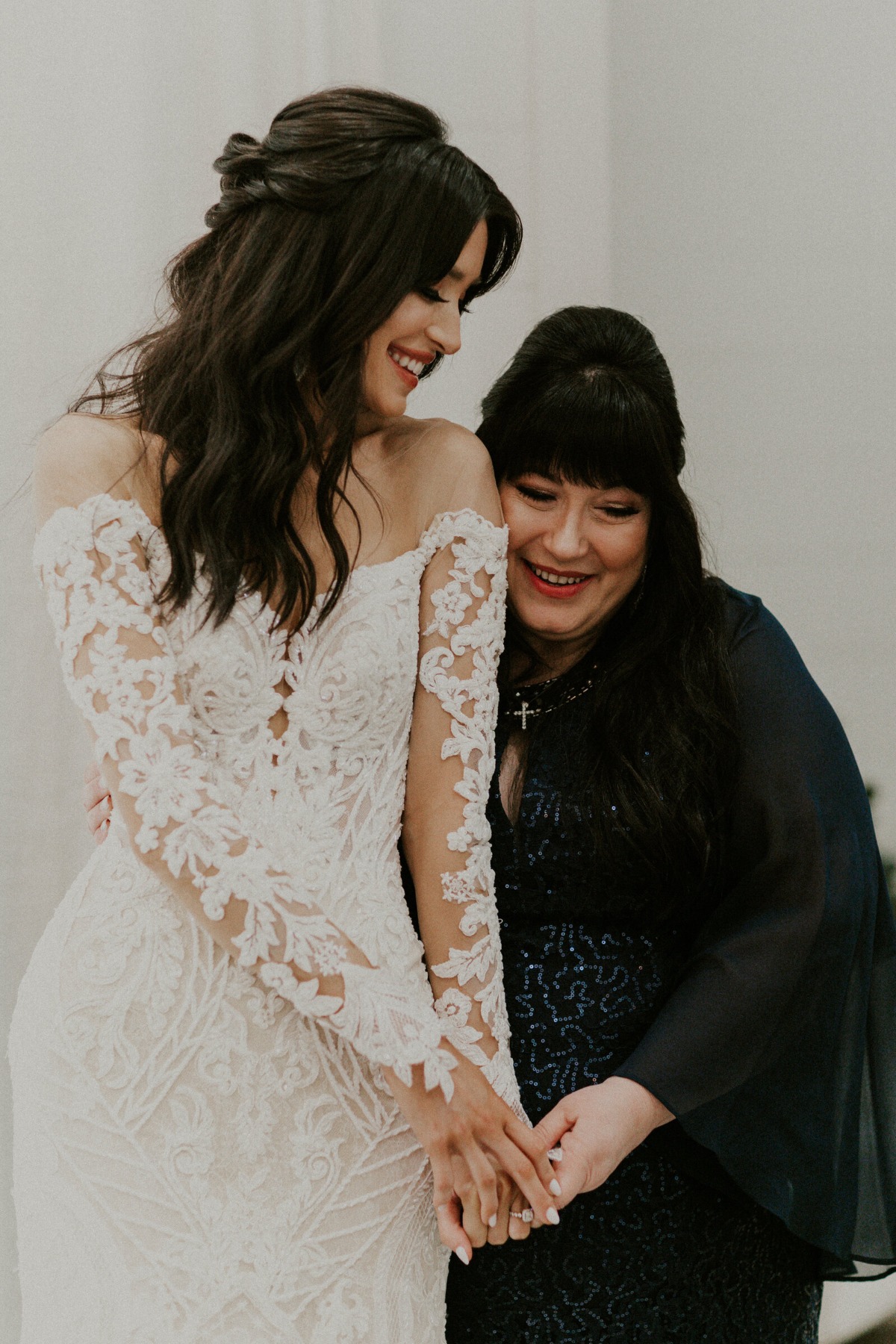 Bride holding hands with mother-of-the-bride