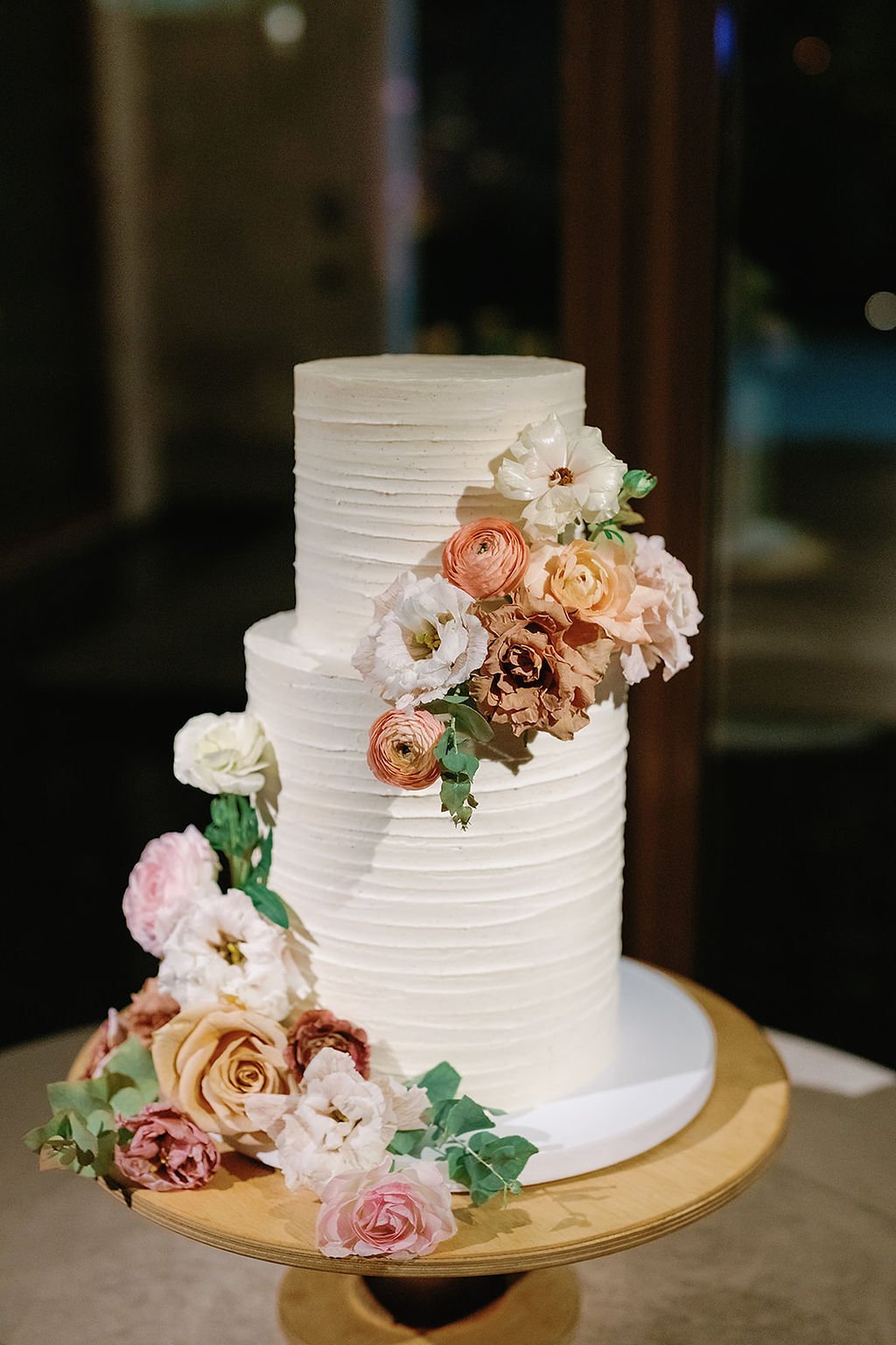 simple buttercream wedding cake with real flower decorations