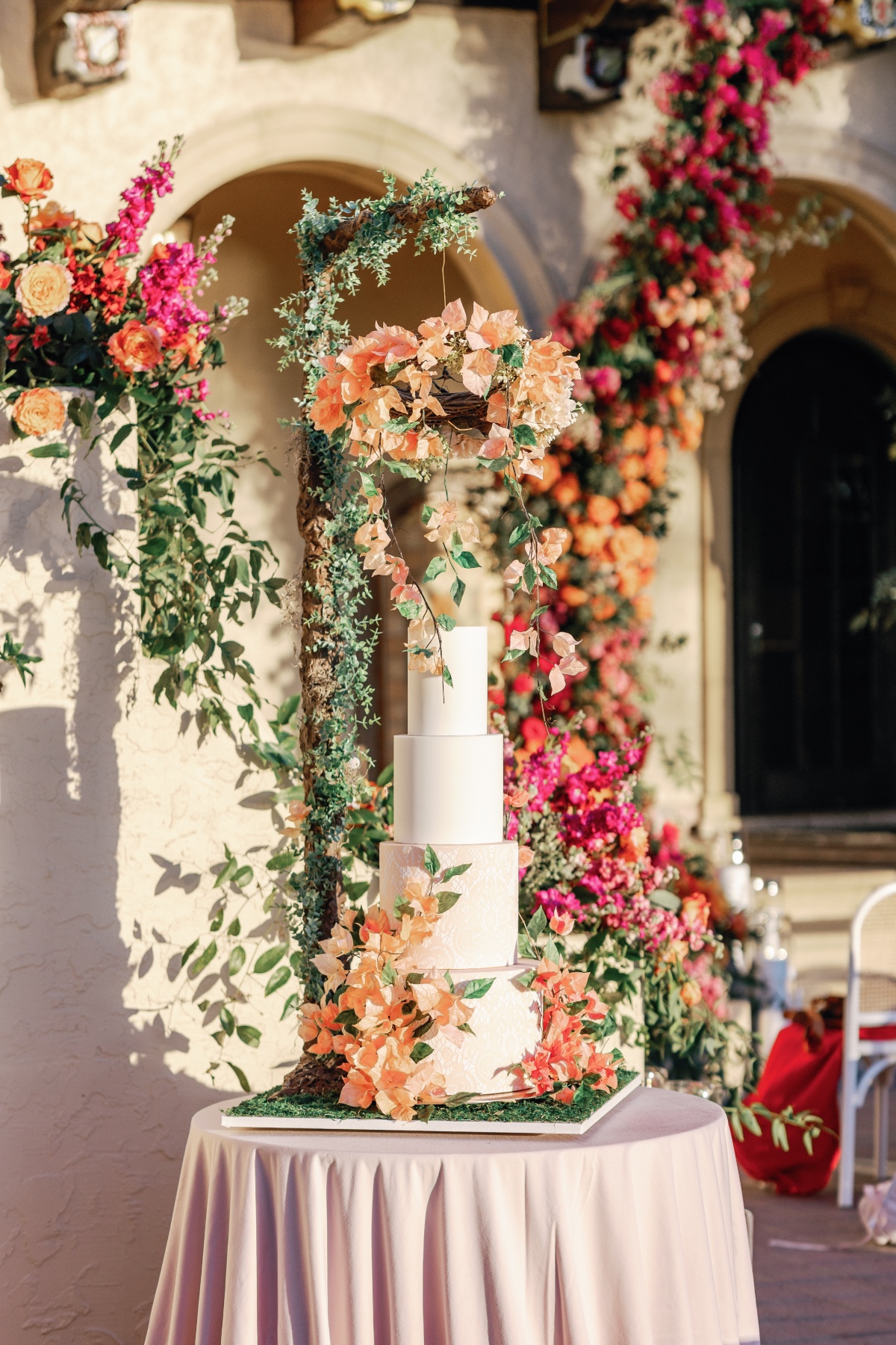 Four tier lace texture wedding cake with hanging peach florals