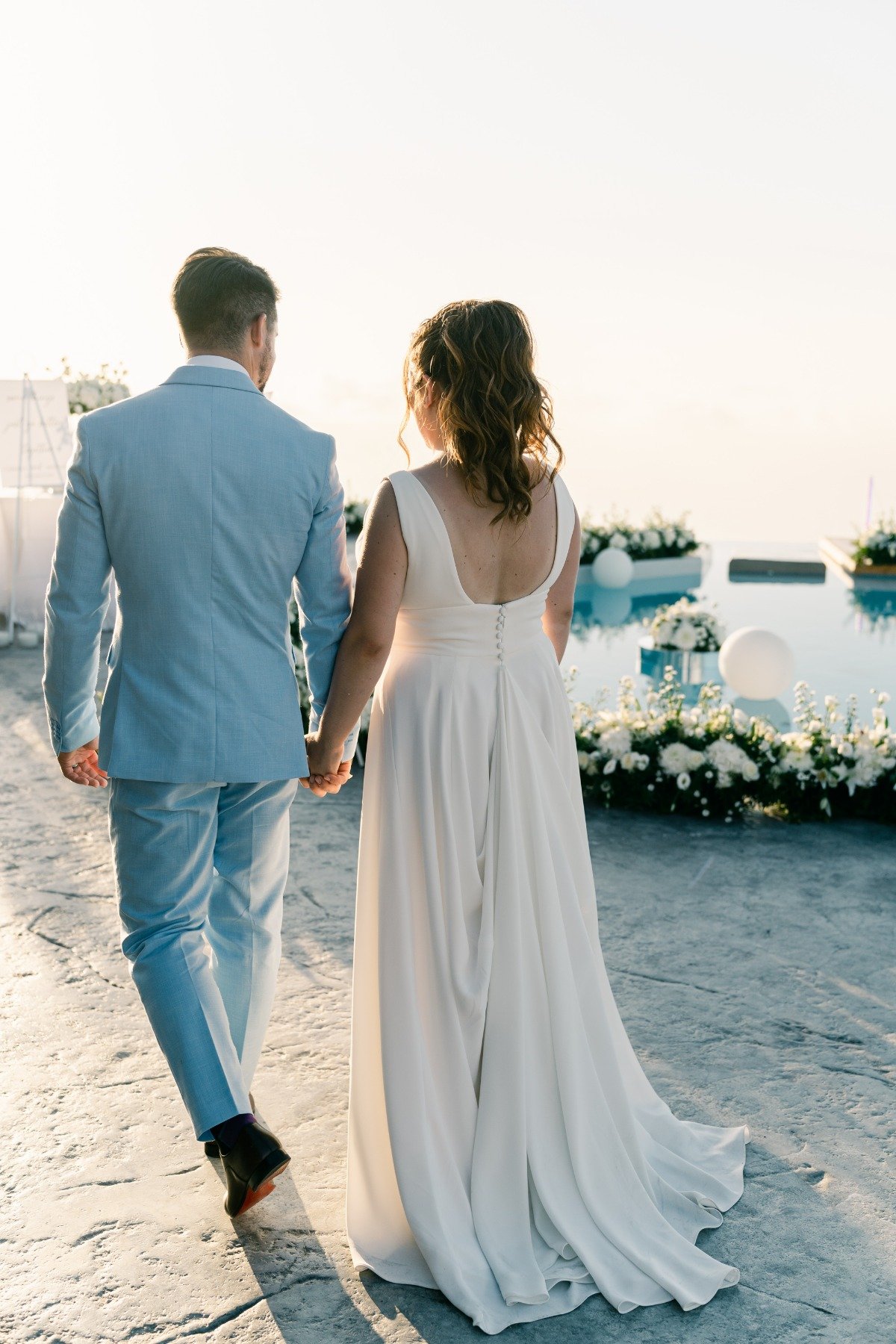 Greek bride and groom walking to reception at island wedding