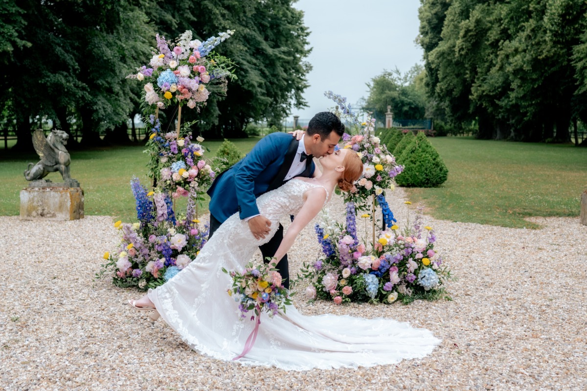 bride and groom kiss in colorful outdoor garden ceremony