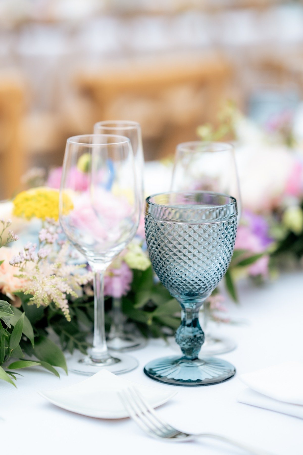 colorful wedding tablescape with pastels and blue glasses