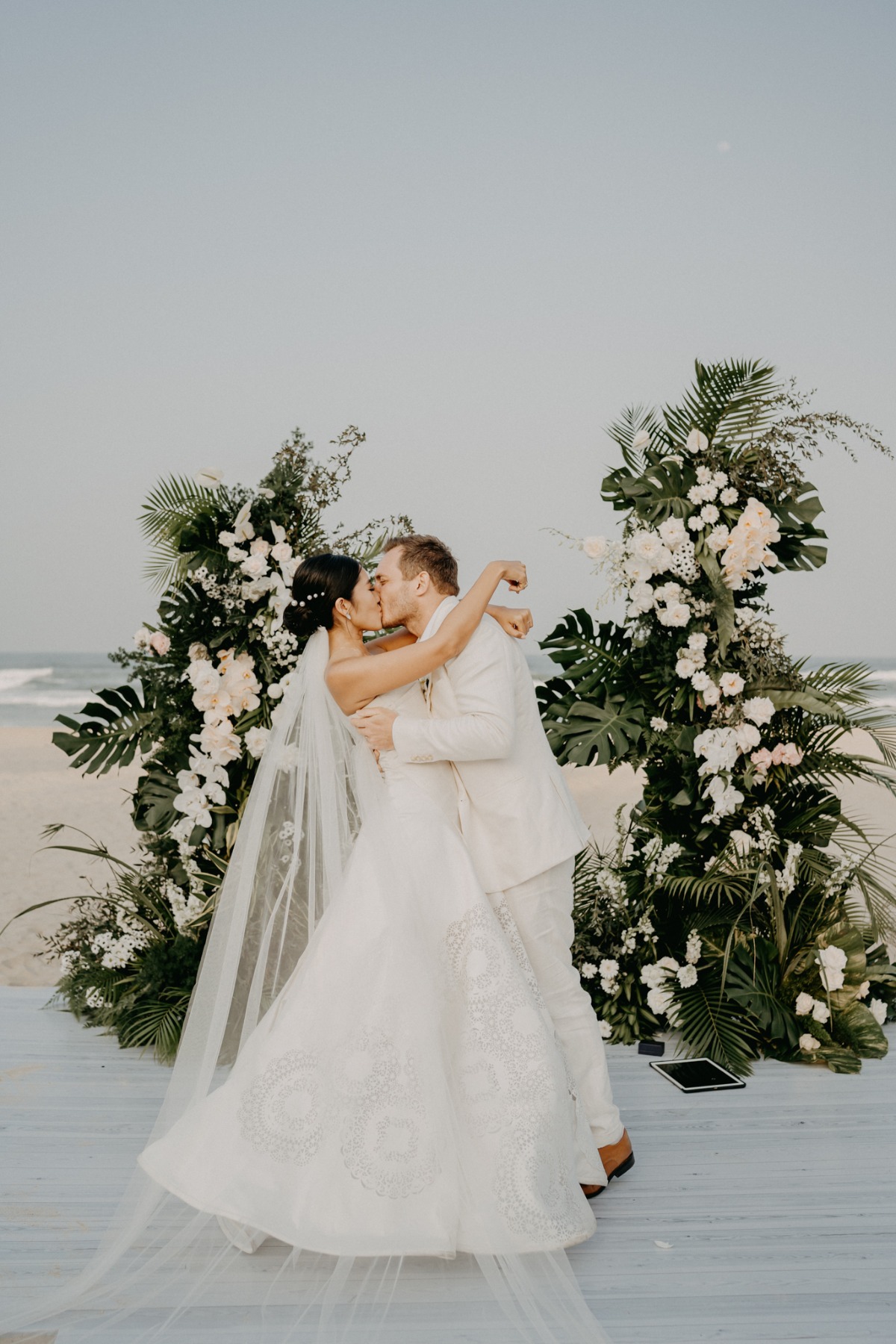 bride and groom kiss at beach ceremony in vietnam