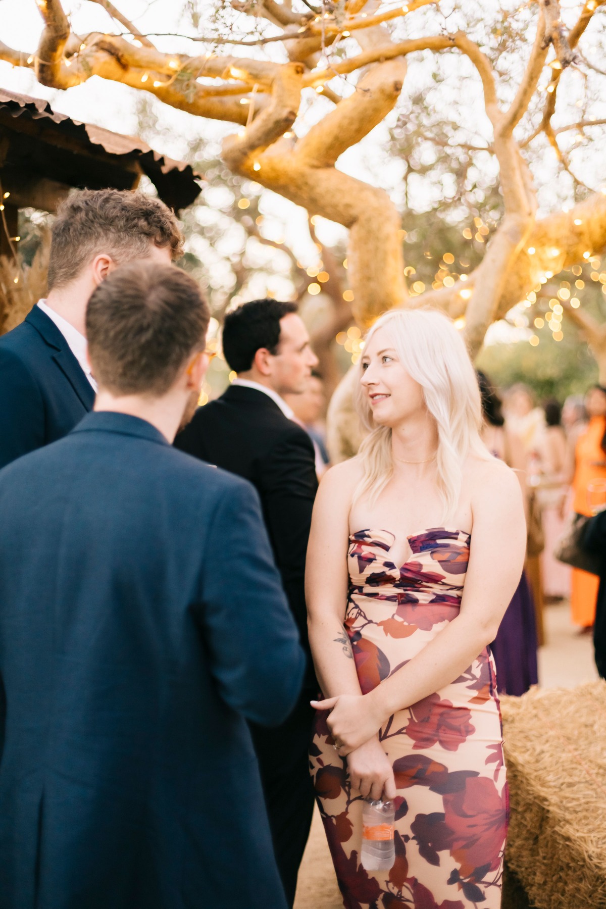 Destination wedding reception guest in stylish floral dress 