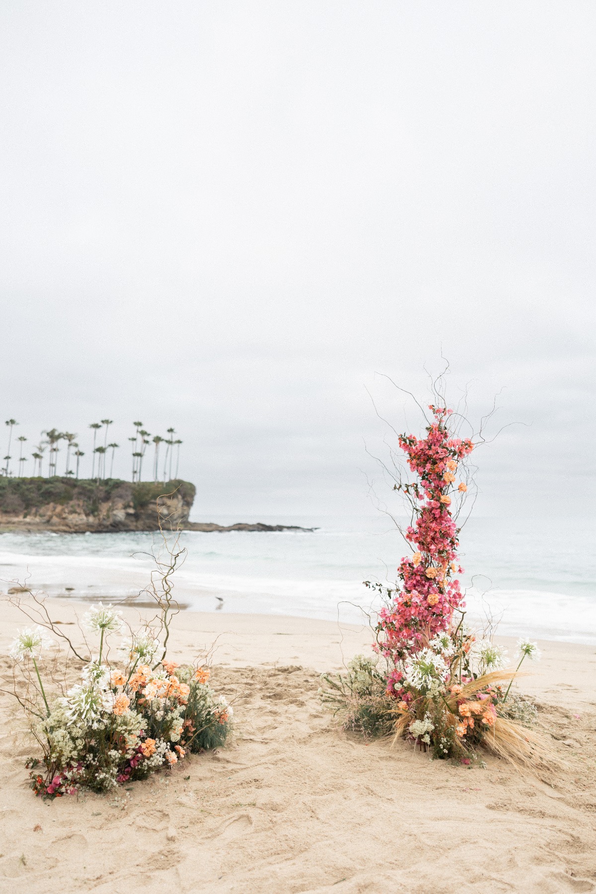 Asymmetrical pink and orange wedding ceremony flowers