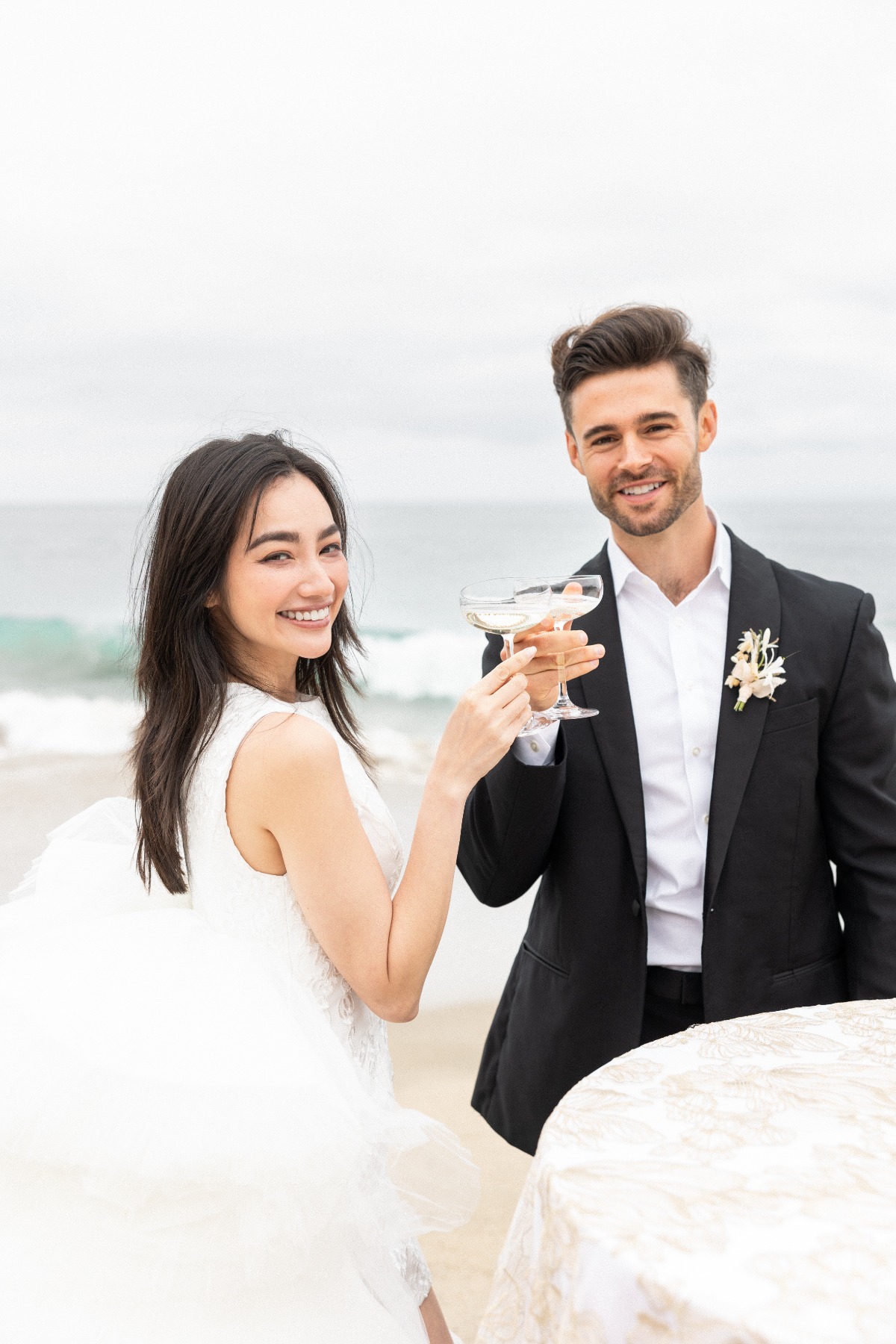 Bride and groom toast from champagne tower on the beach 