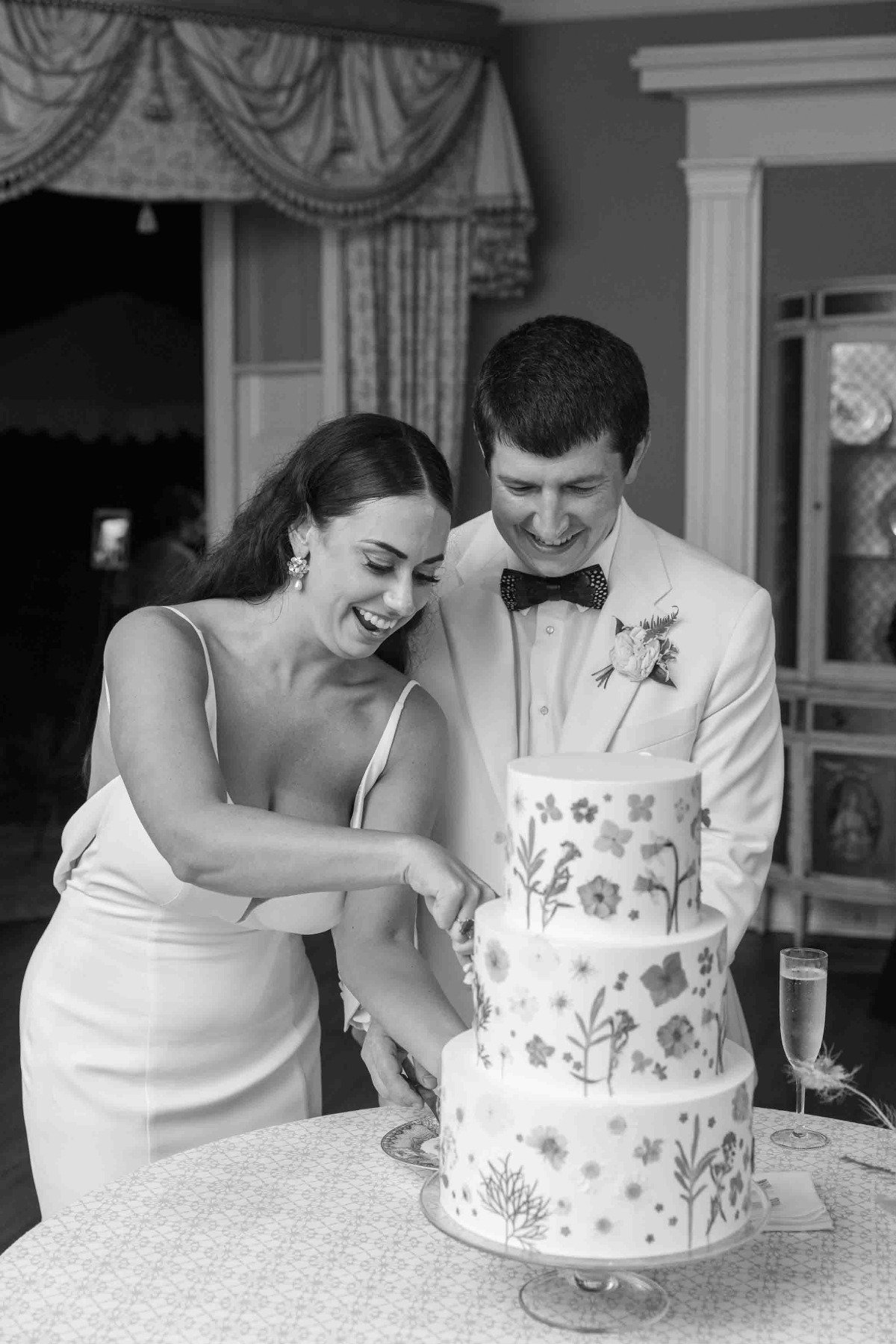 Modern bride and groom cutting dried floral wedding cake 