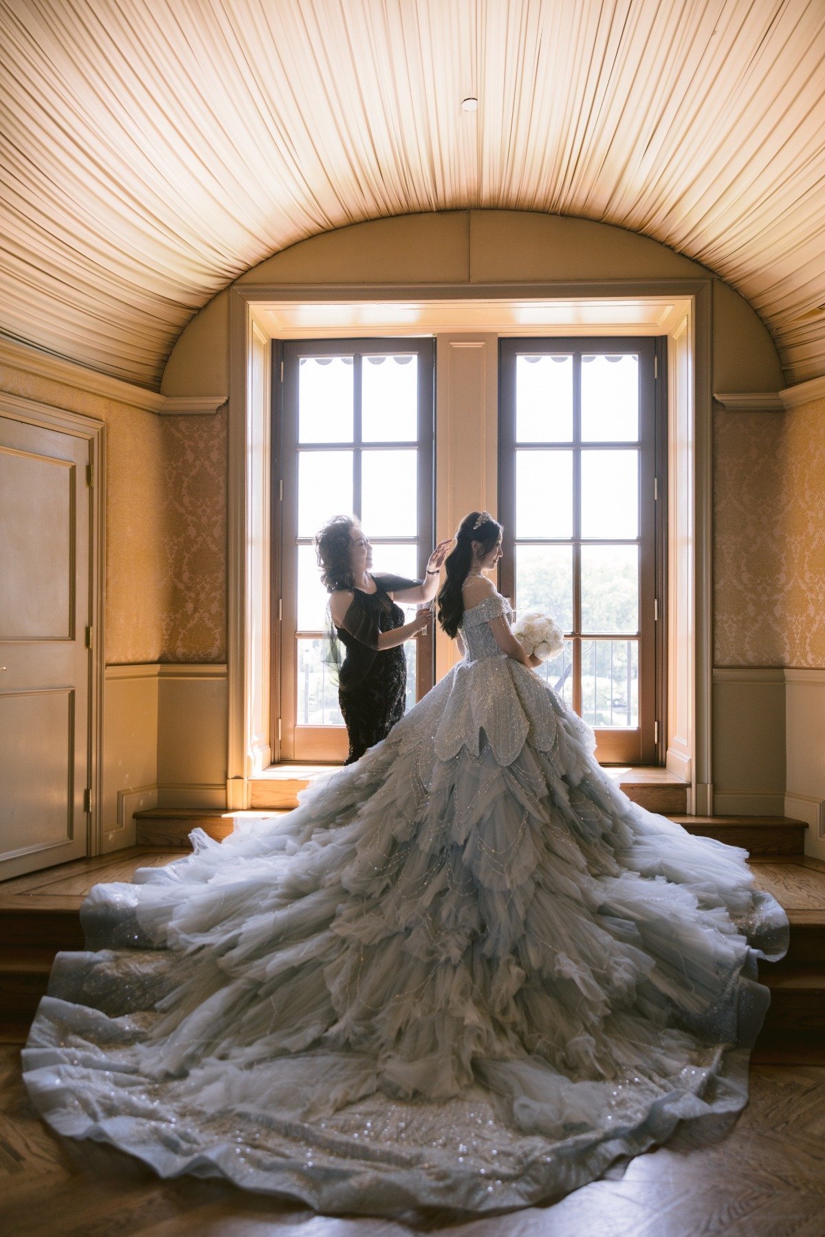 bride in ballgown with mother getting ready