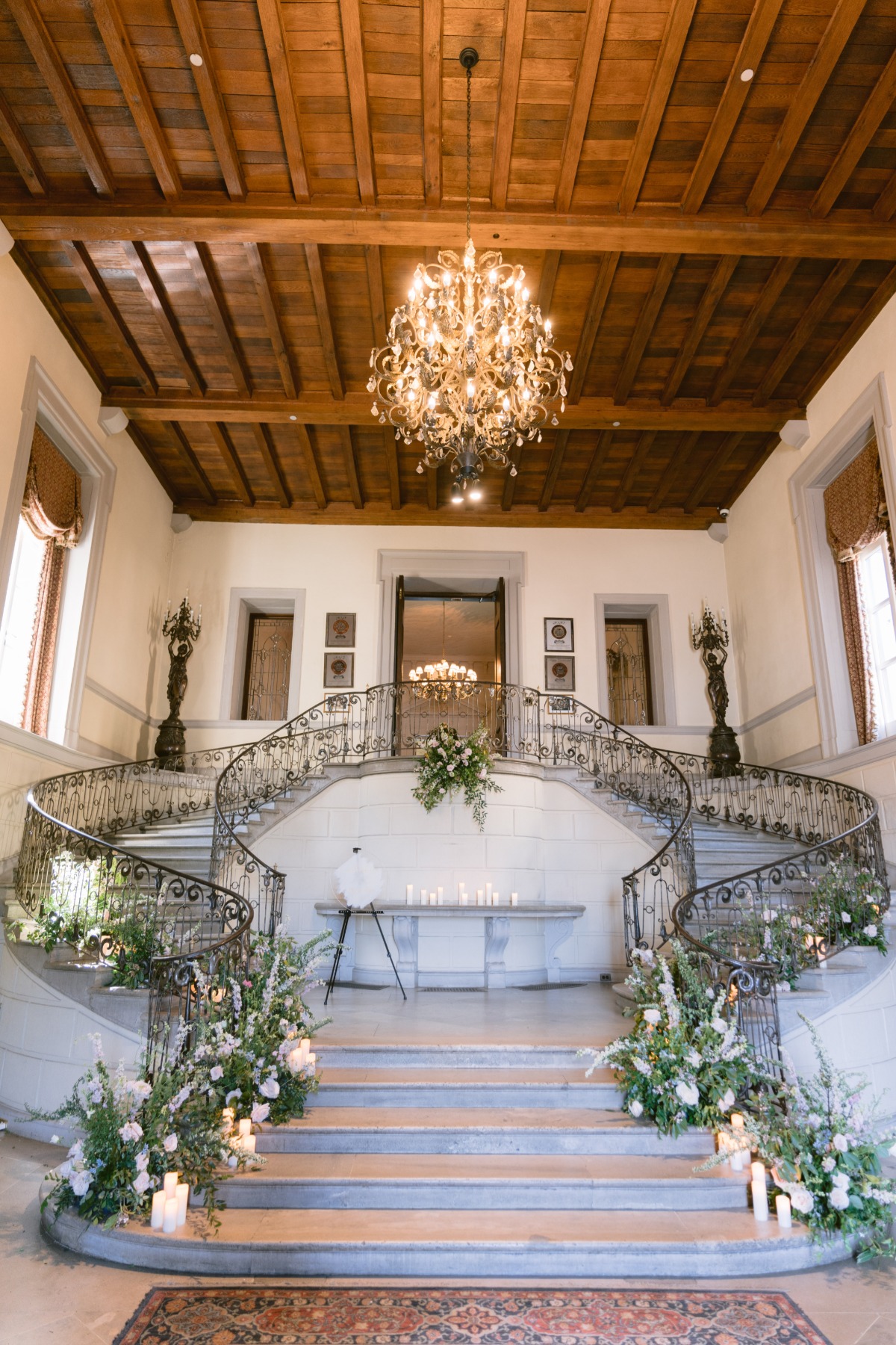 grand staircase in castle with floral arrangements