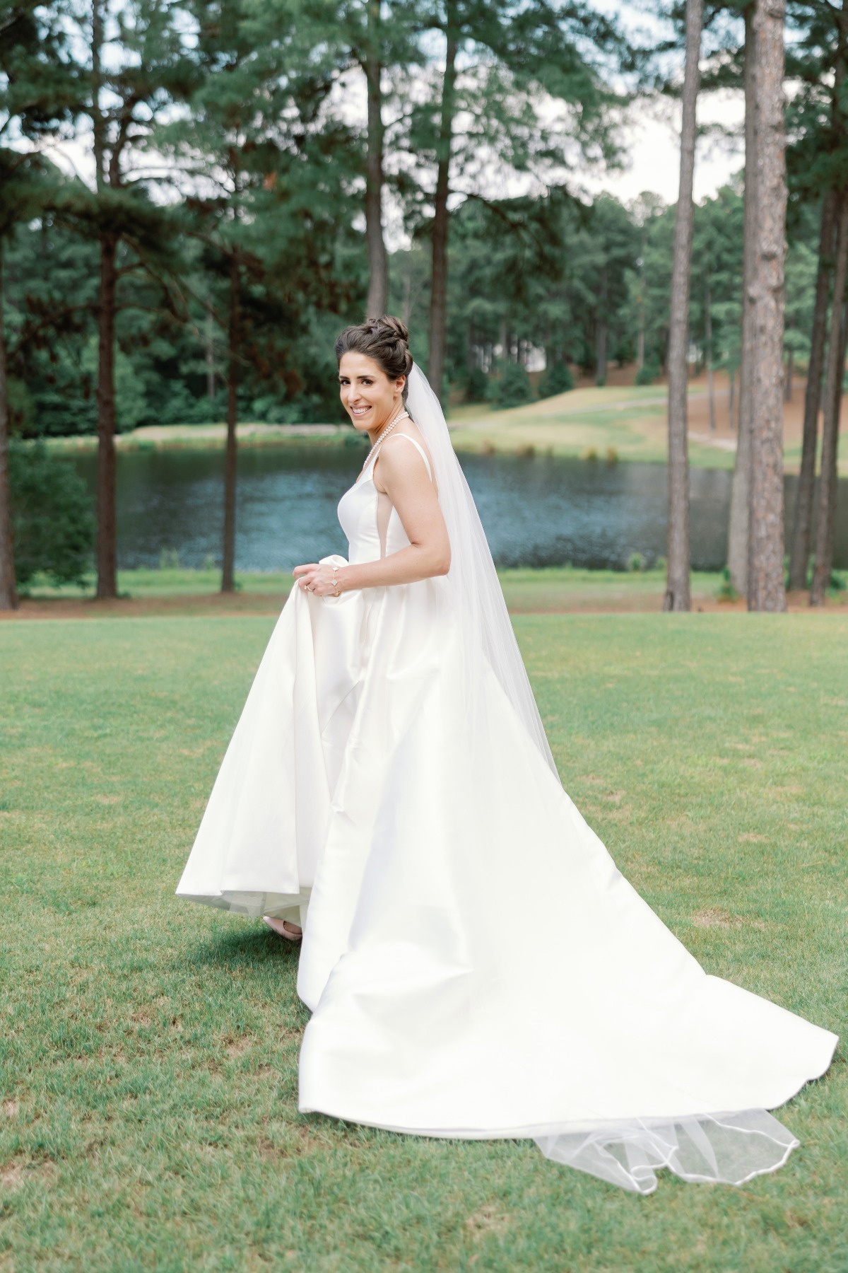 bride at golf club in a line gown with long veil