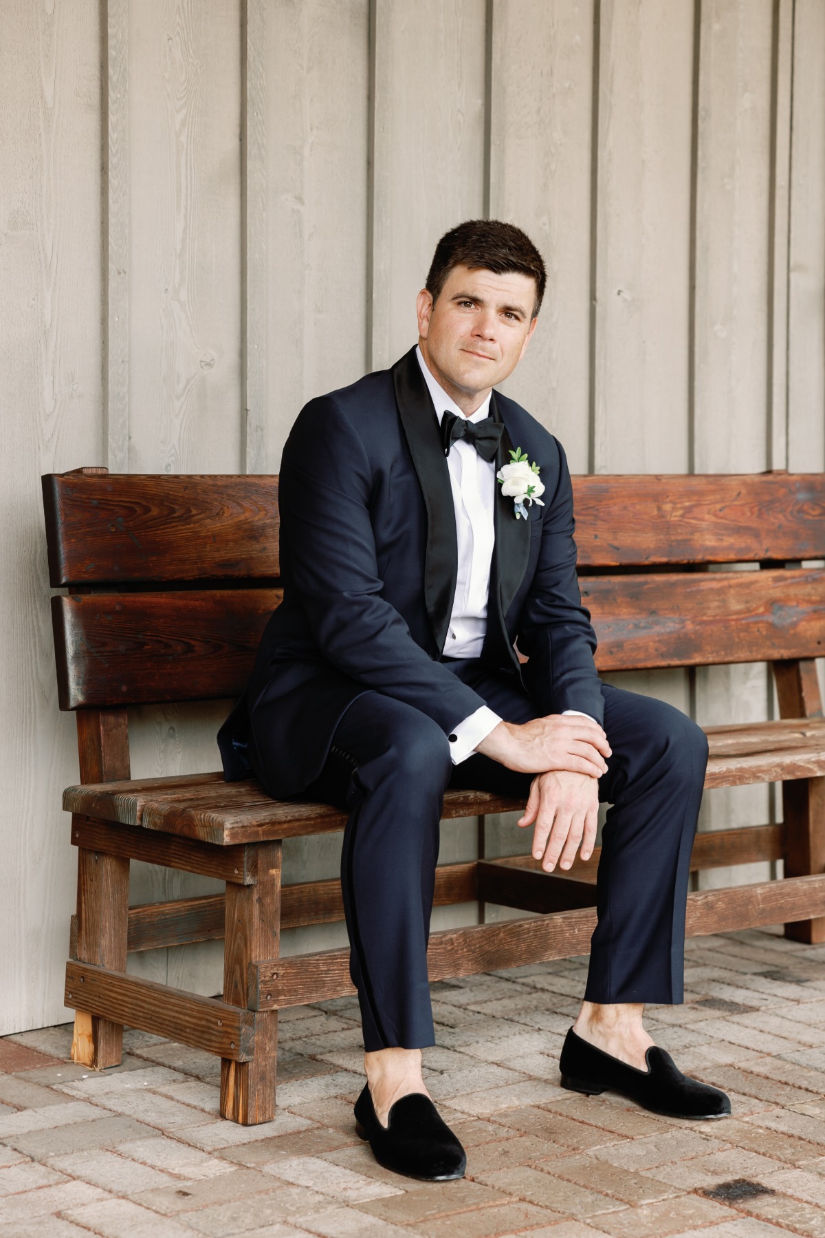 groom in dark blue tuxedo with black accents