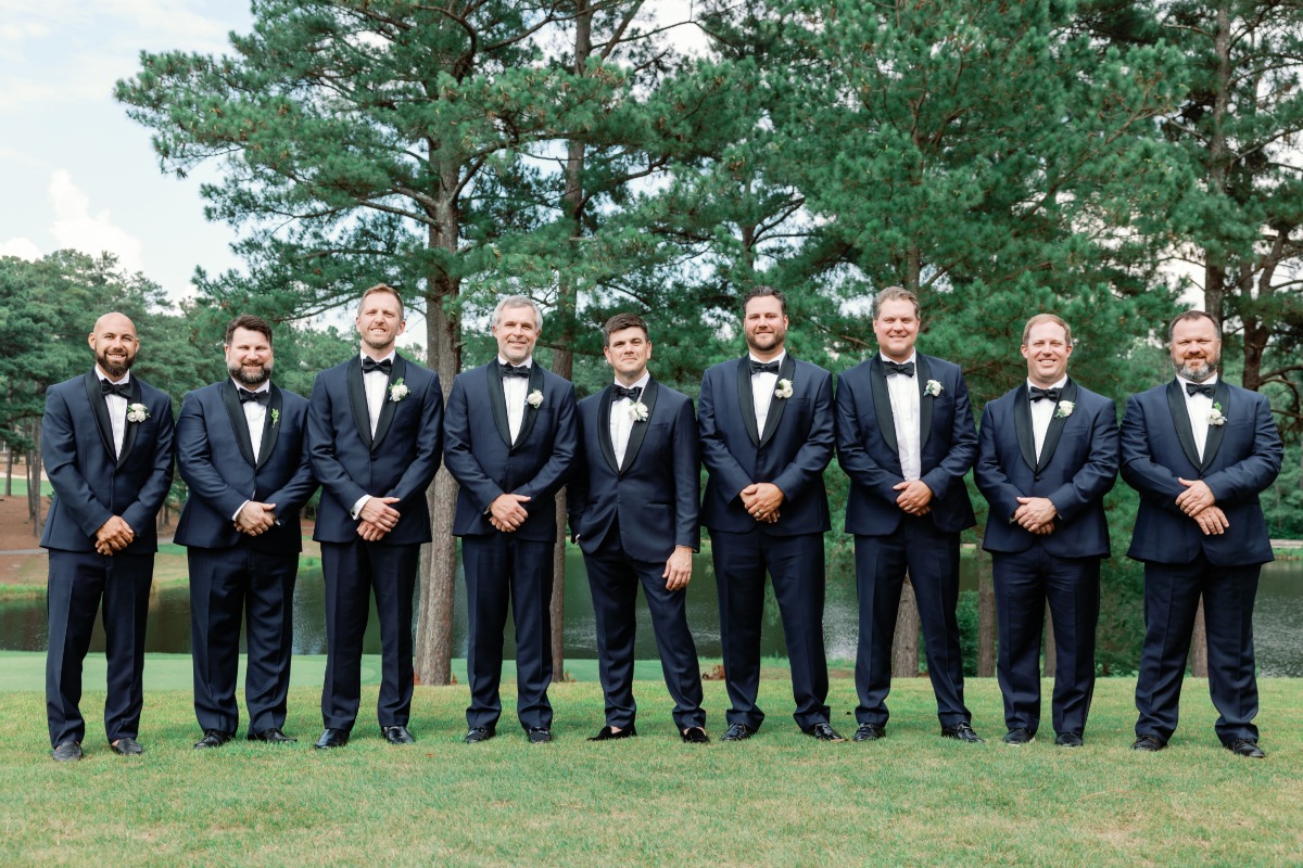 groomsmen in dark blue tuxedos and black accents