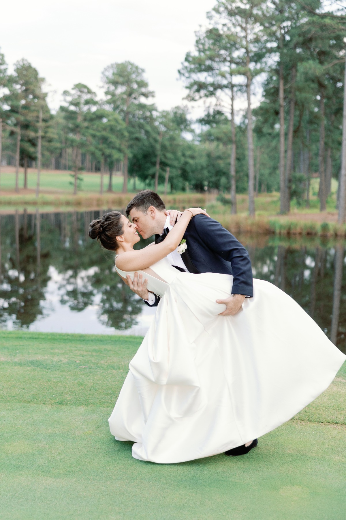 bride and groom kiss at golf club wedding in north carolina