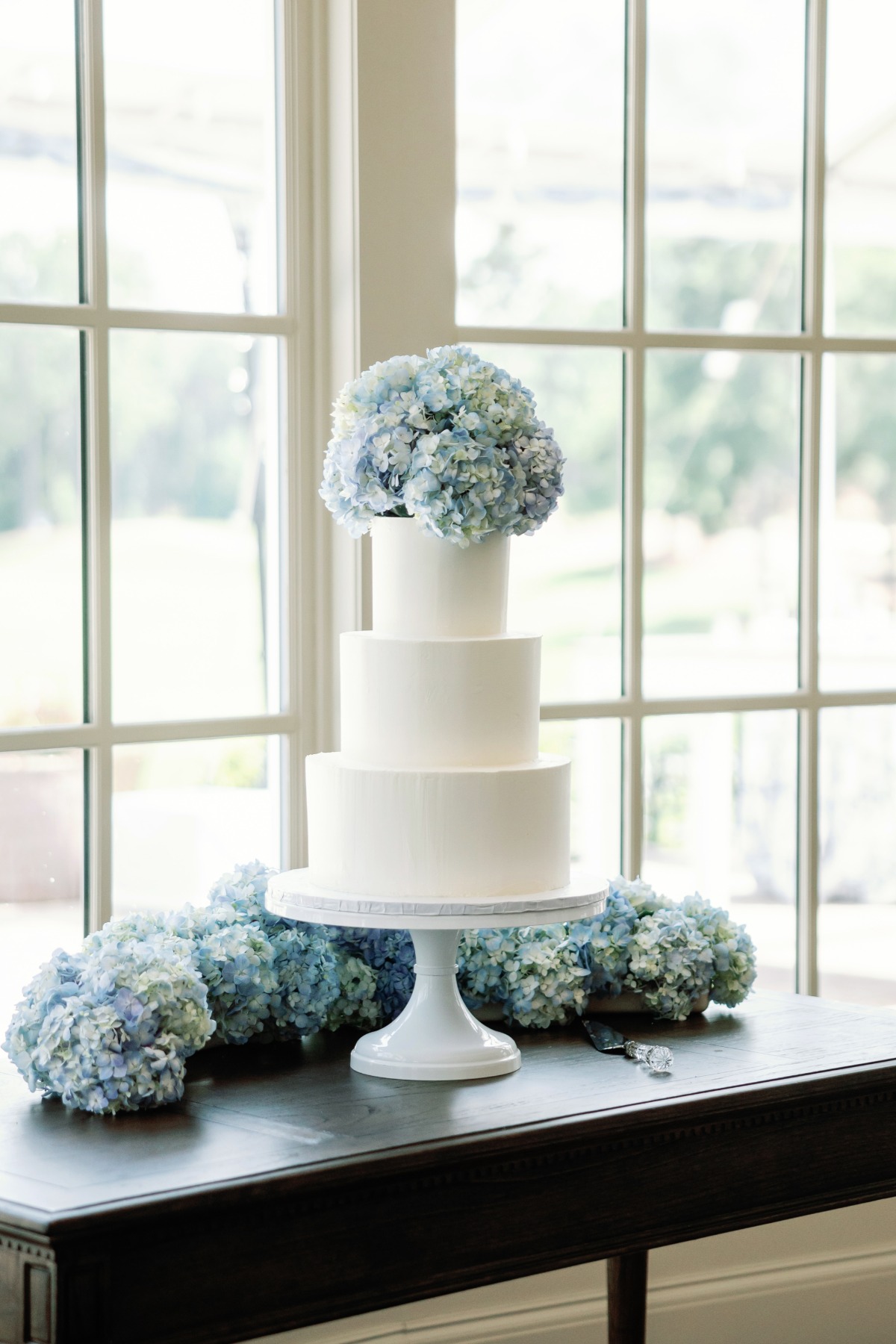 buttercream wedding cake with fresh blue and white hydreangas