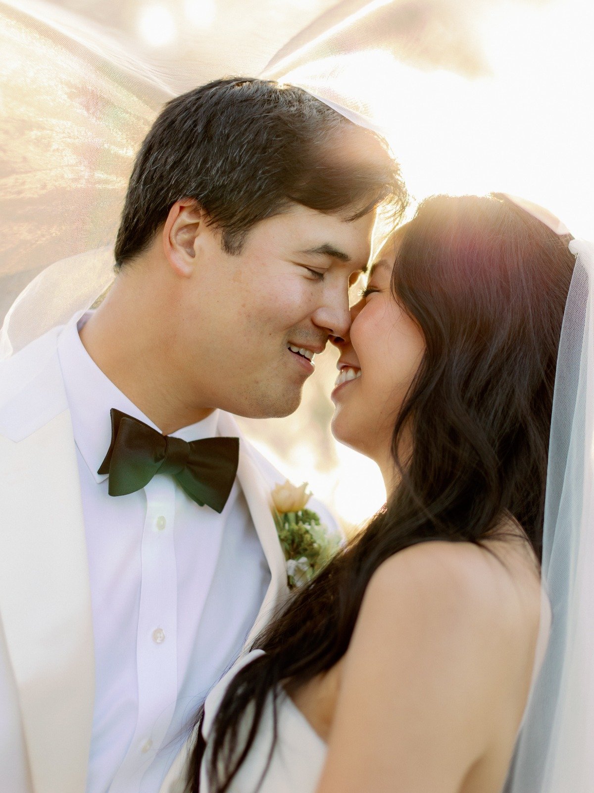 bride and groom kiss under veil 