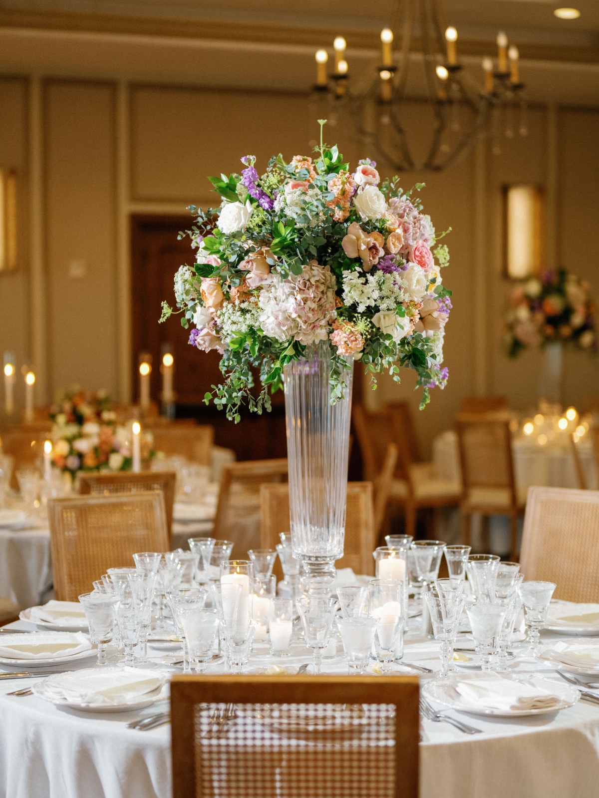 tall muted colorful centerpiece in clear vase