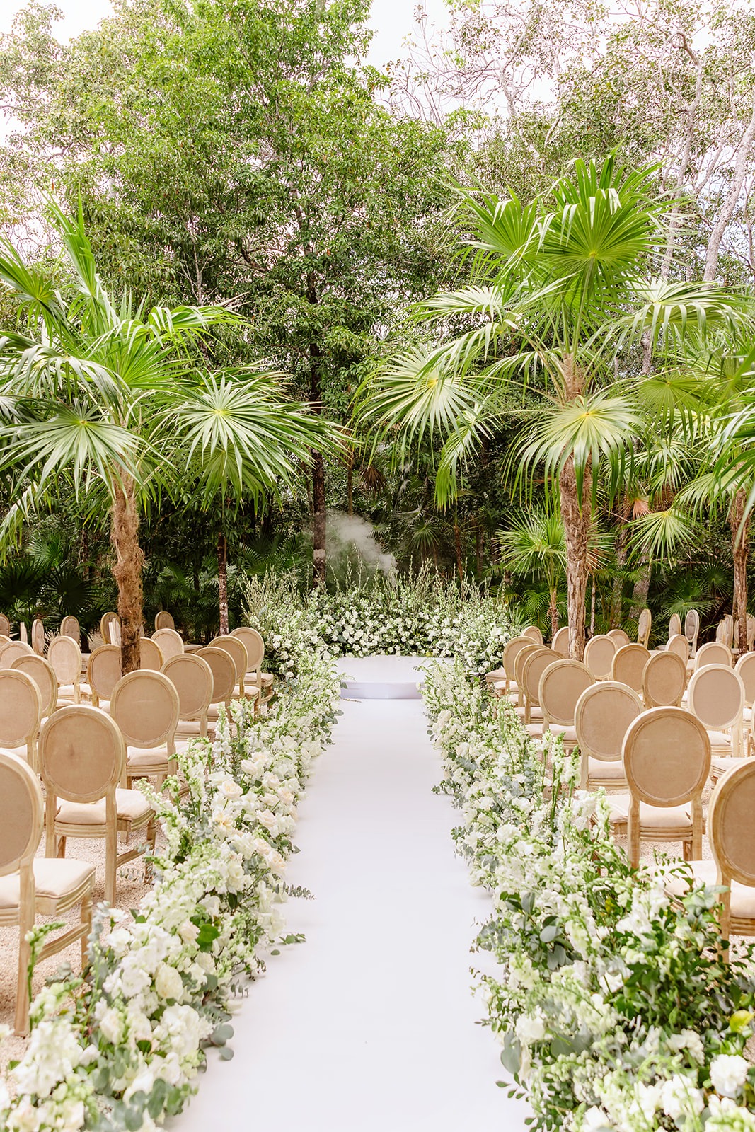 Lush white and green ceremony florals at Tulum jungle wedding
