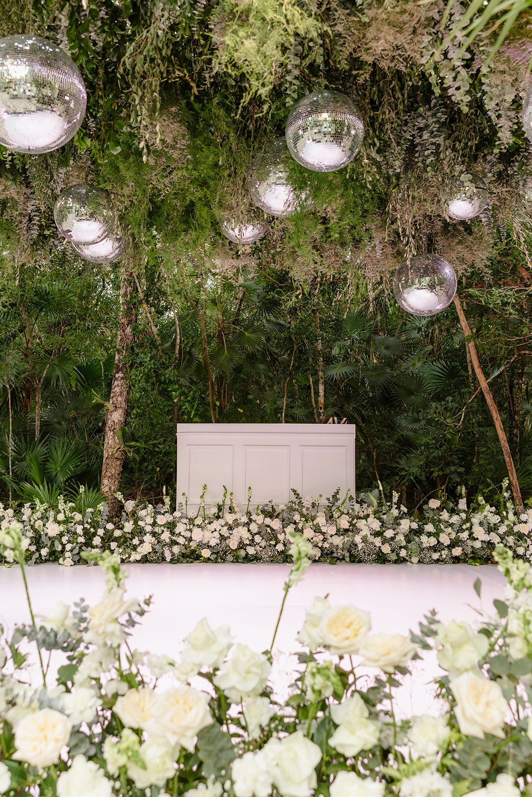 Disco jungle dance floor surrounded by white roses in Tulum 