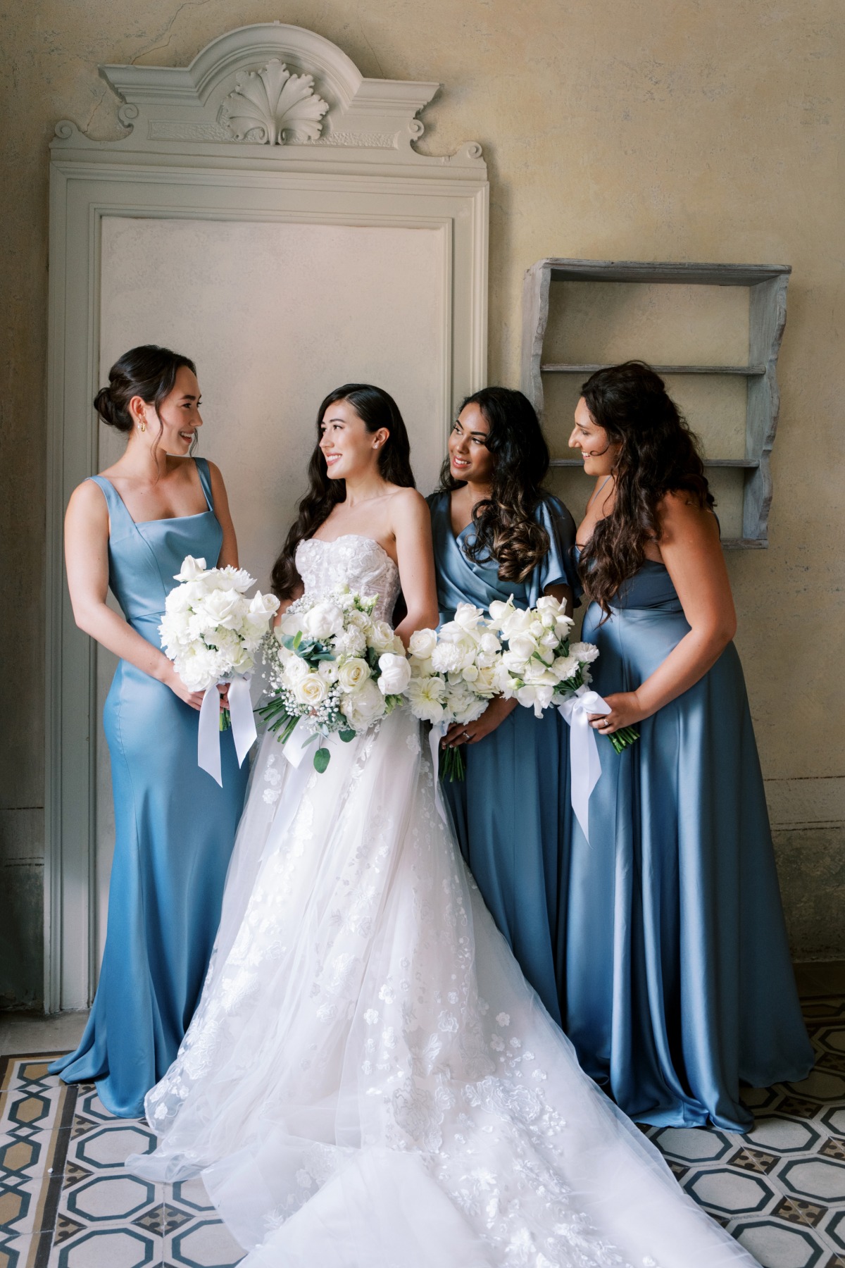 bride in champagne and ivory ballgown with bridesmaids in blue