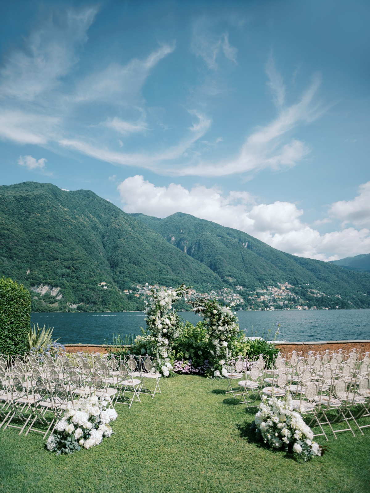 asymmetrical white floral arch at lake como wedding ceremony