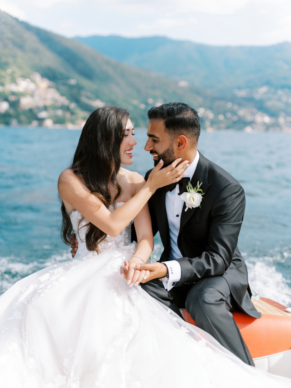 bride and groom share boat ride on lake como