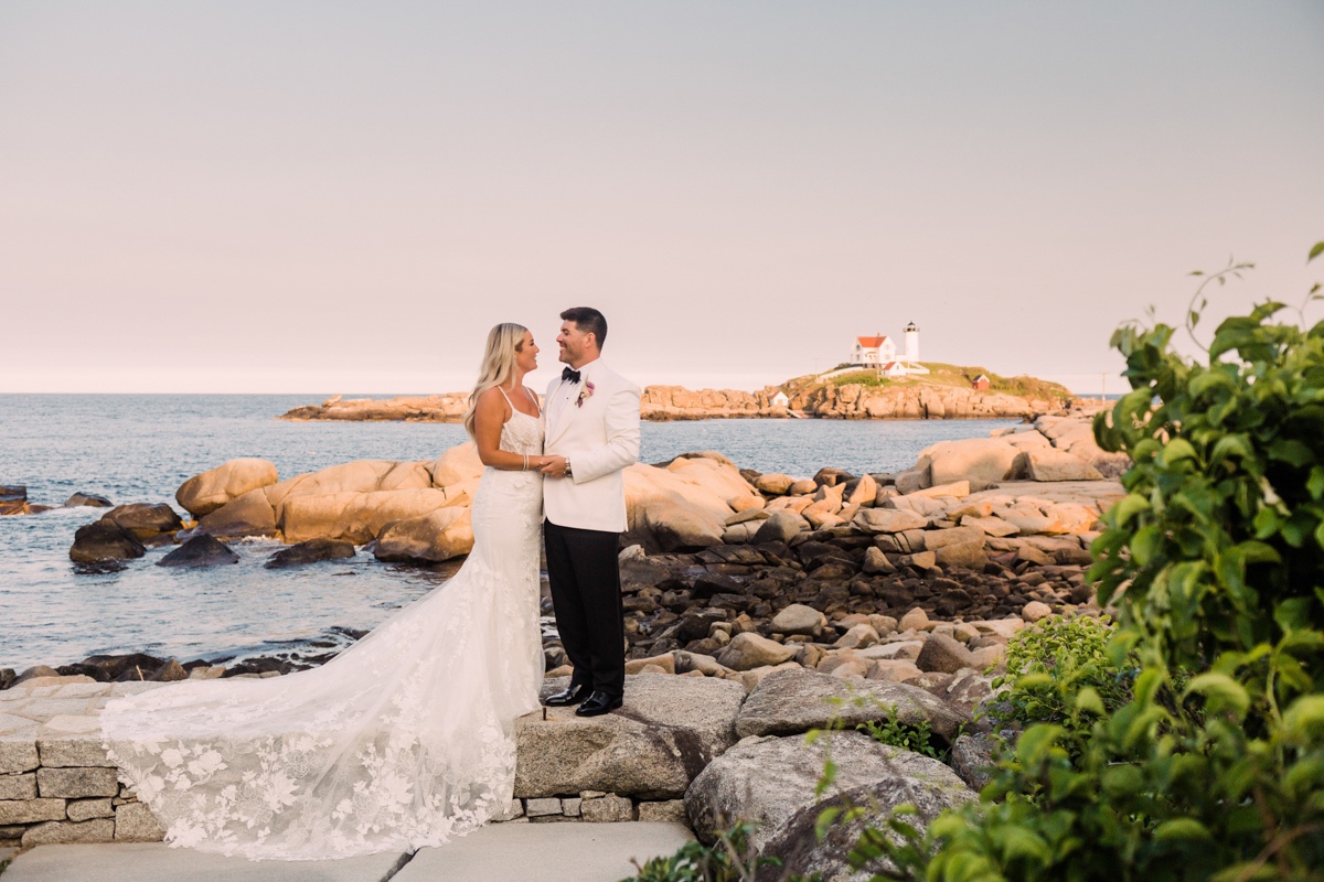 bride and groom pose in front of lighthouse