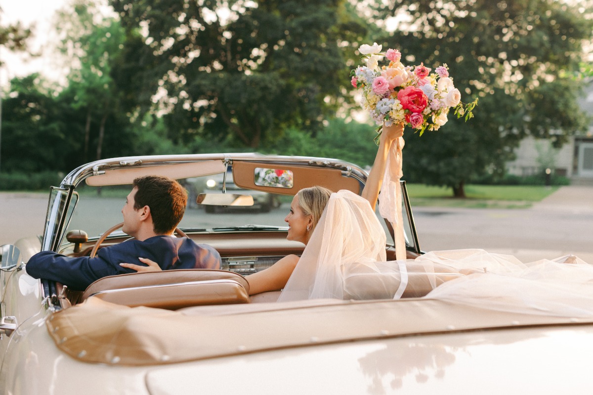 bride and groom leave wedding in vintage convertible 