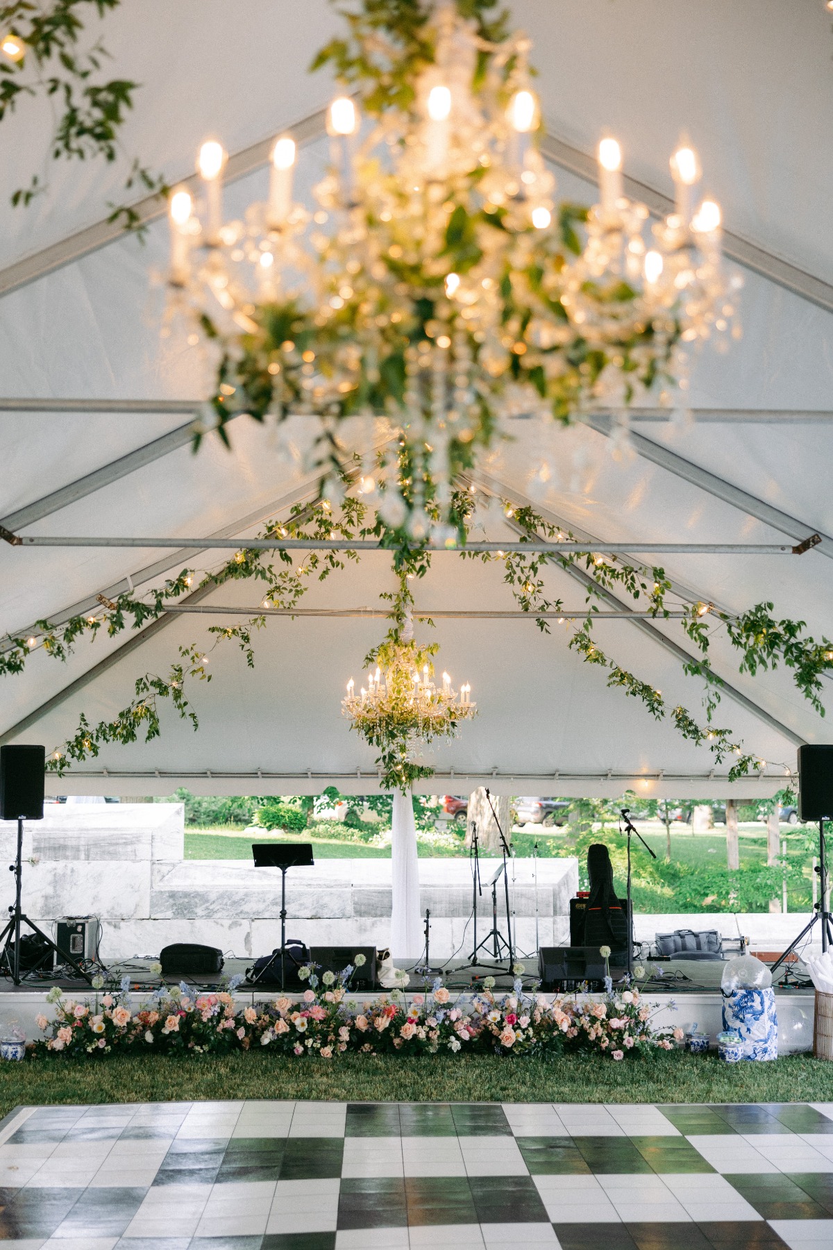 outdoor tented reception with vines and checkerboard floor