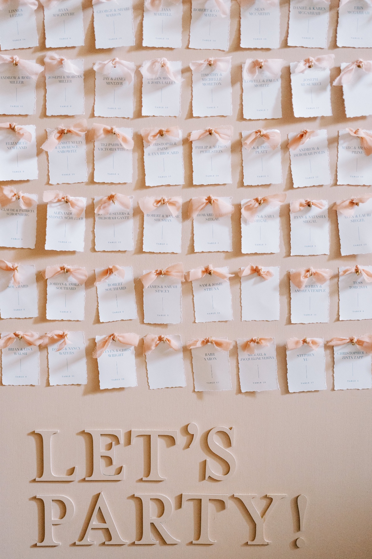 white escort cards with pink bows