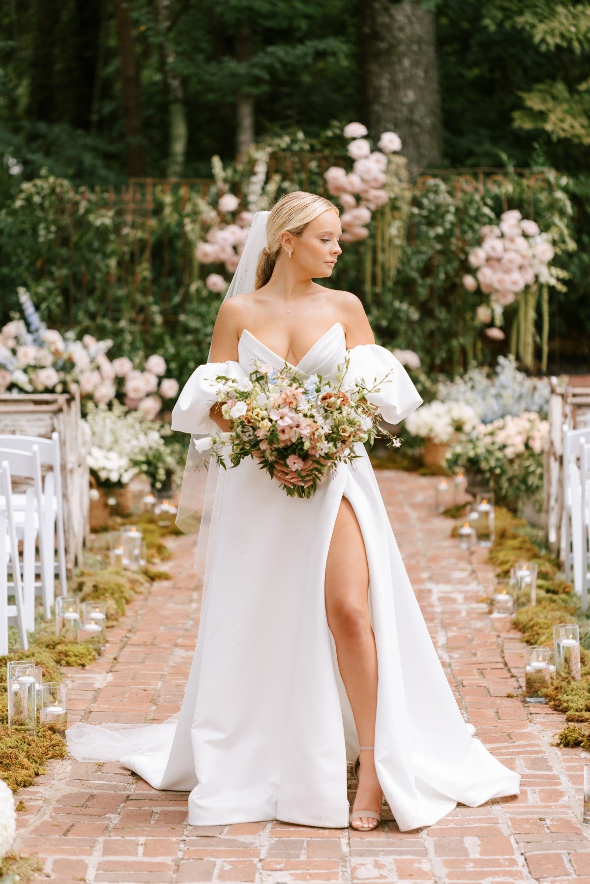 bride poses at garden wedding ceremony with bouquet