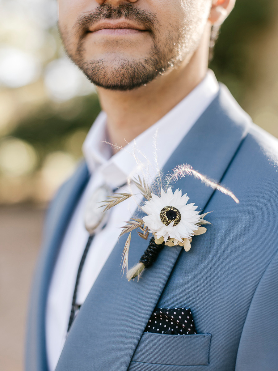 groom in pastel blue suit with black western accents