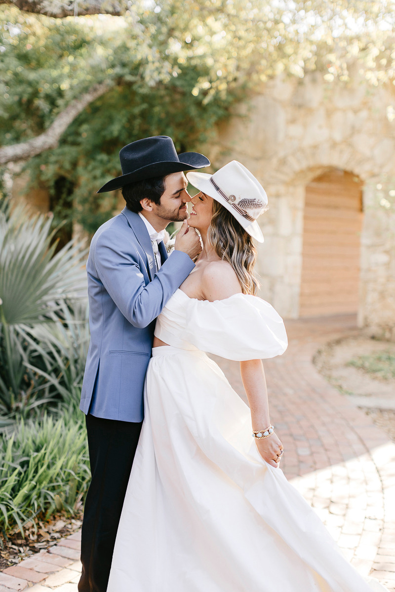 bride and groom in western wedding attire with stetson hats