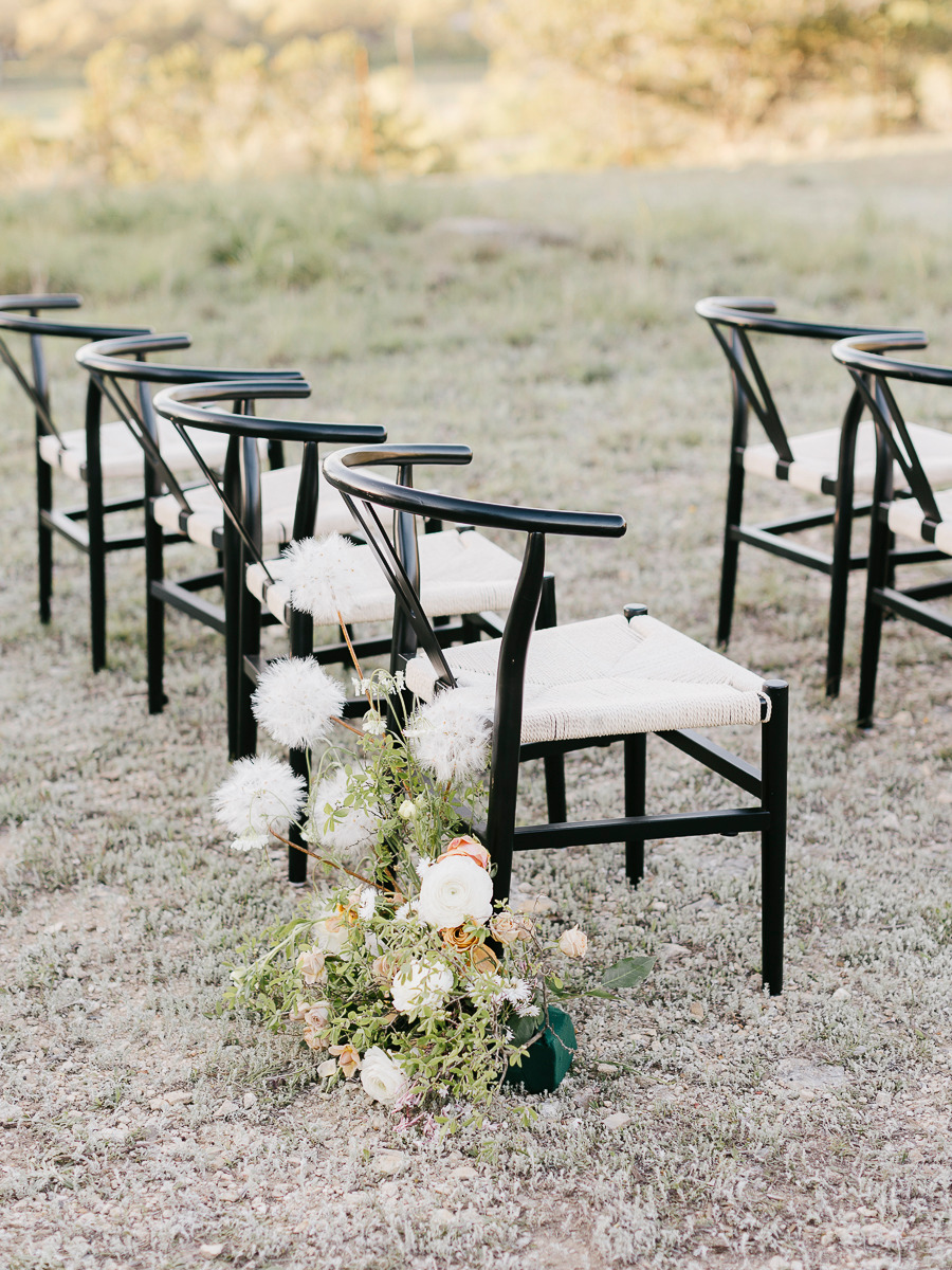 black chairs and floor florals for outdoor wedding