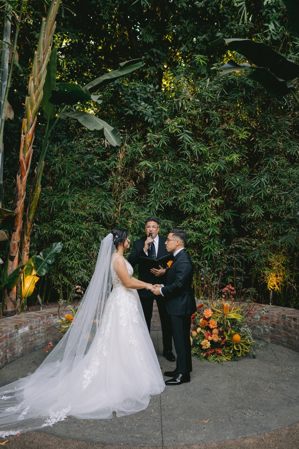 bride and groom exchange vows in tropical courtyard LA