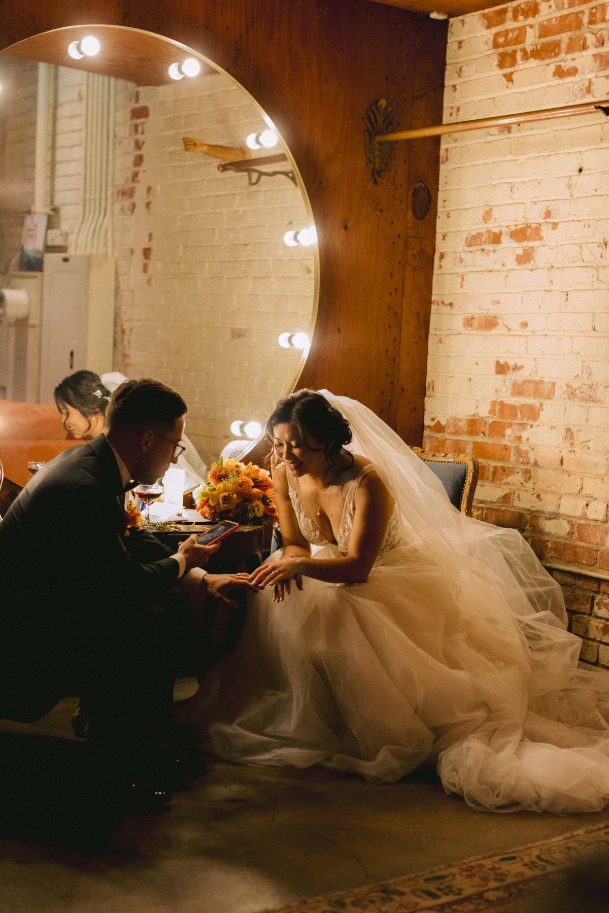 bride and groom take photos of wedding rings