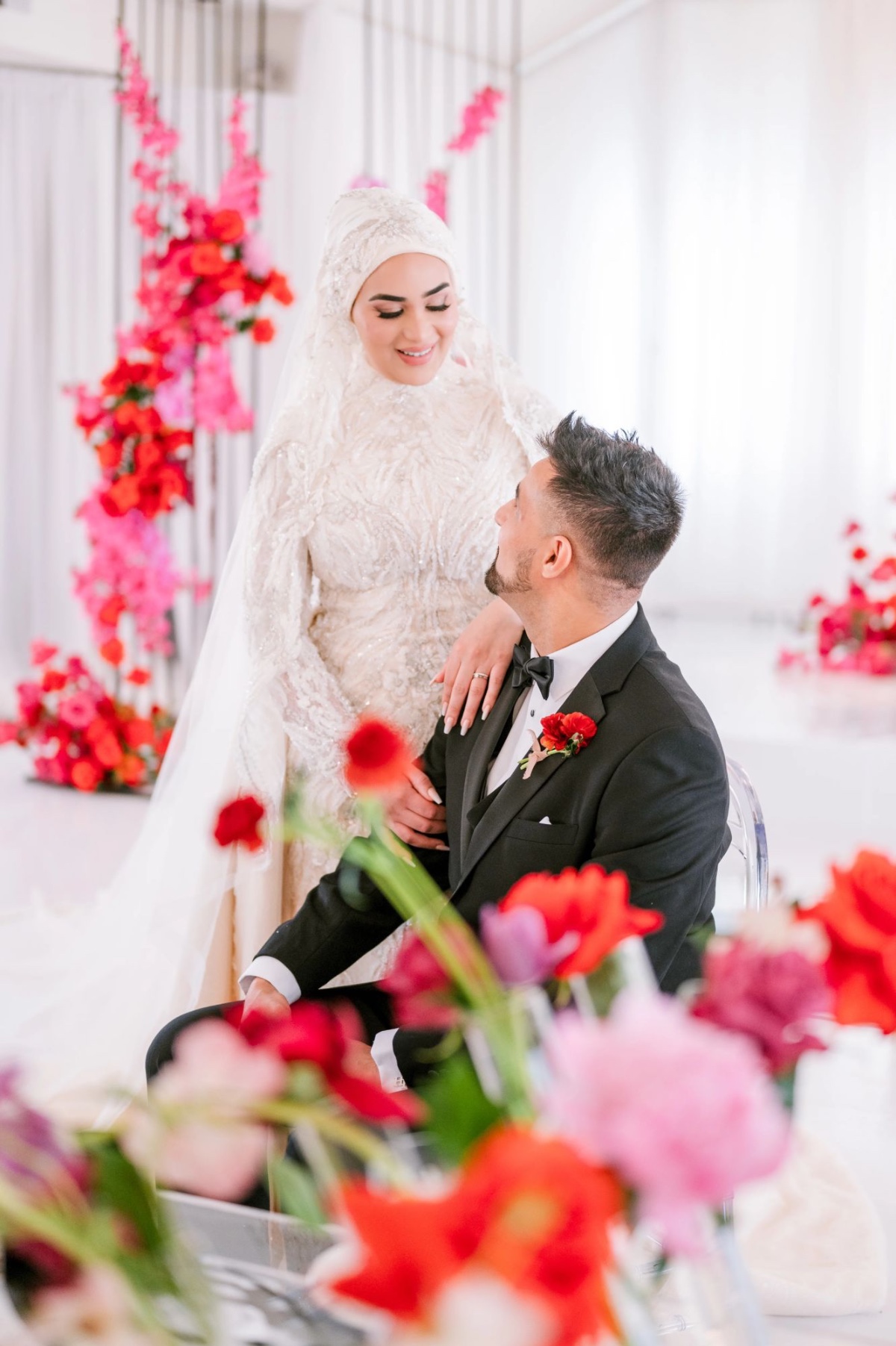 bride and groom with pink red and fuchsia florals