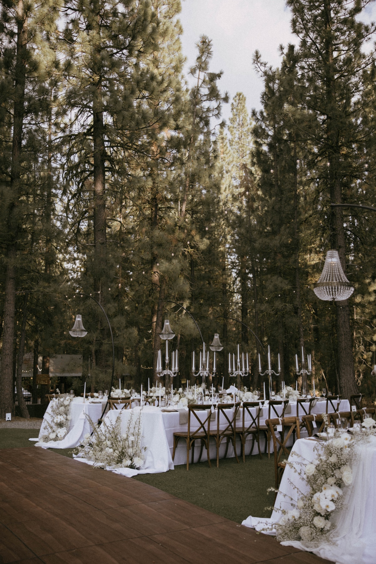 hanging chandeliers and candelabras in a forest wedding