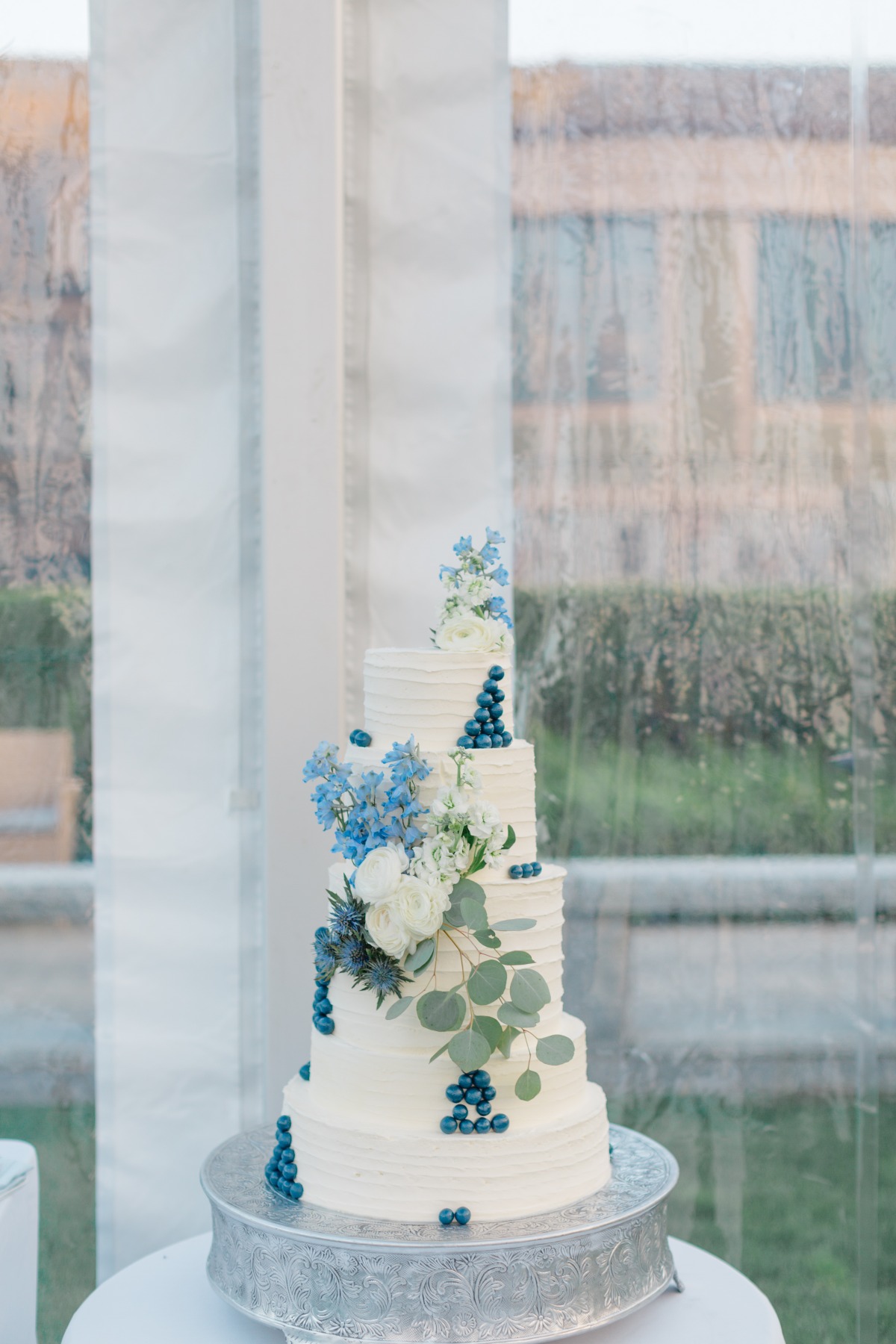 blueberries and fresh flowers on wedding cake