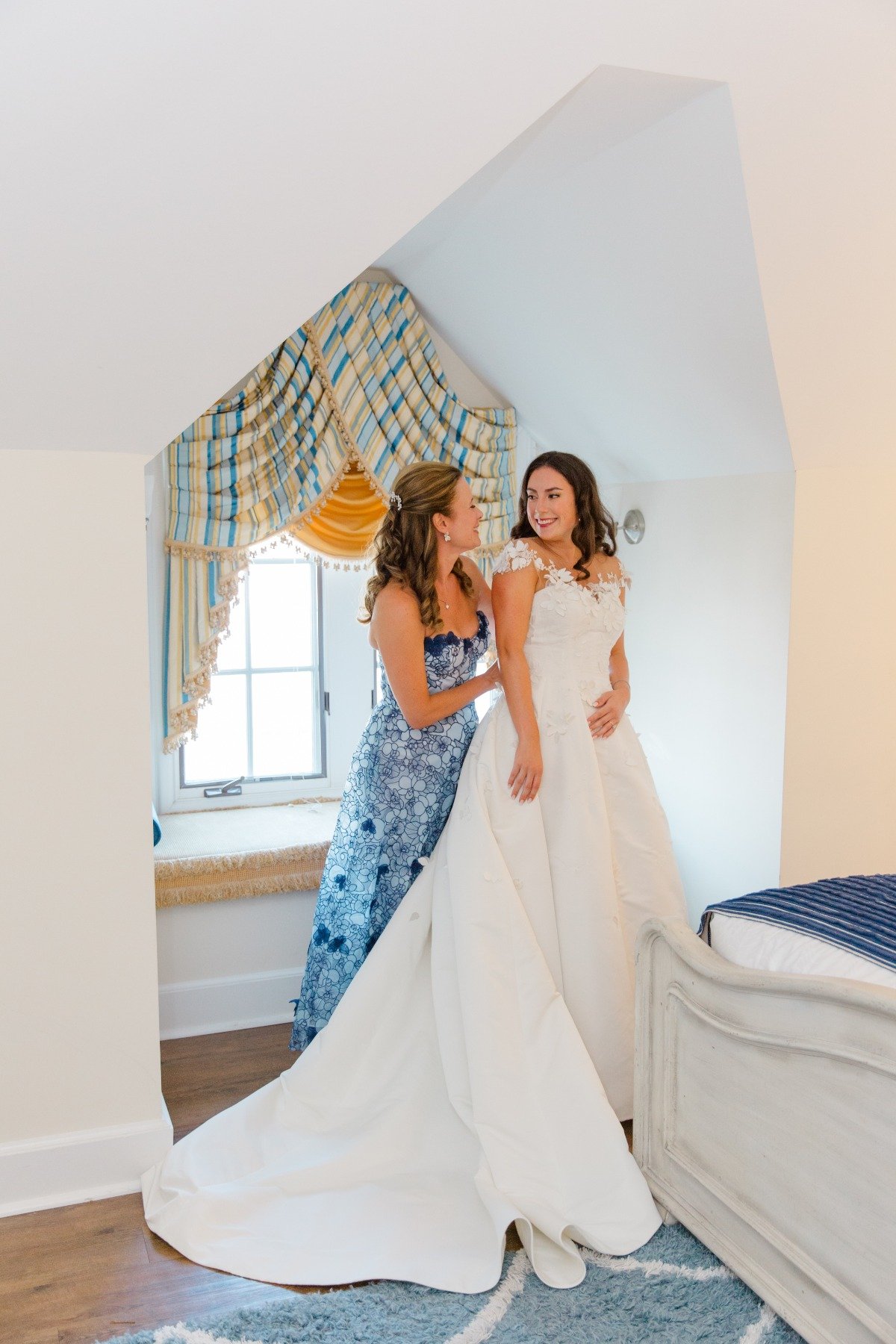 mom helping bride into dress on wedding day