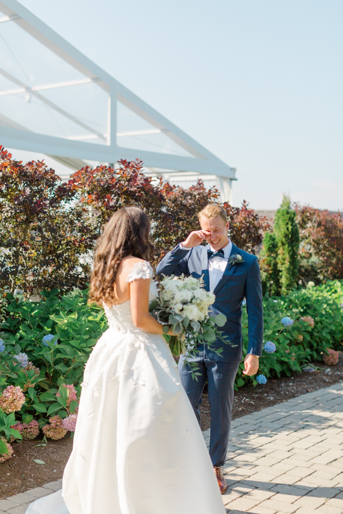 groom tears up at first look with bride in garden